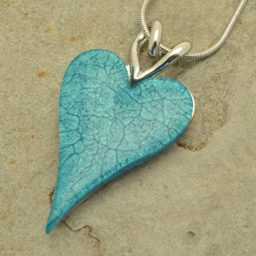 Turquoise heart-shaped pendant on a beige background