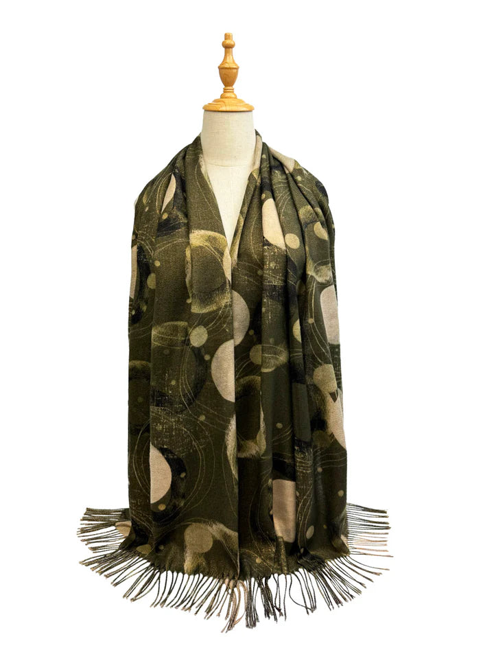 Green patterned scarf with fringes on a mannequin against a white background