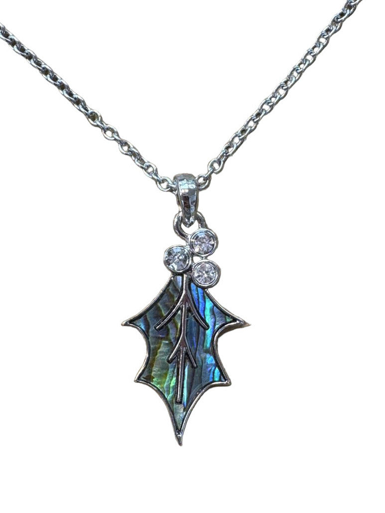 Holly leaf shaped pendant with gemstones on a chain against a white background
