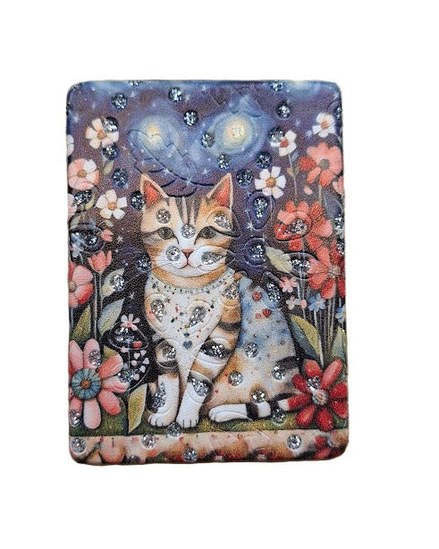 Compact mirror with a cat surrounded by flowers and a night sky.