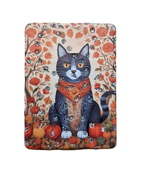 Compact mirror with a cat illustration surrounded by autumn-themed elements on a beige background.